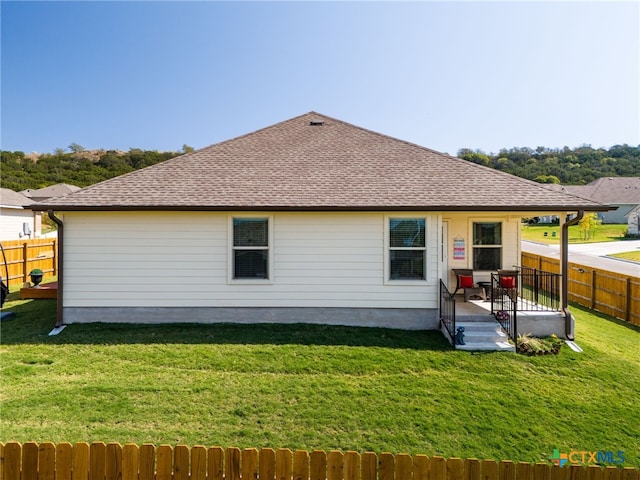 rear view of property featuring a lawn