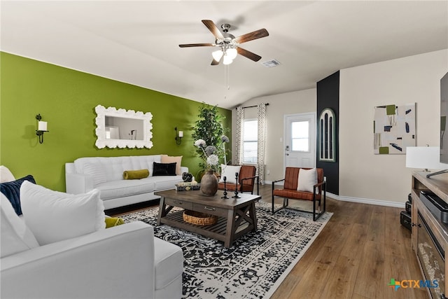 living room with wood-type flooring, ceiling fan, and vaulted ceiling