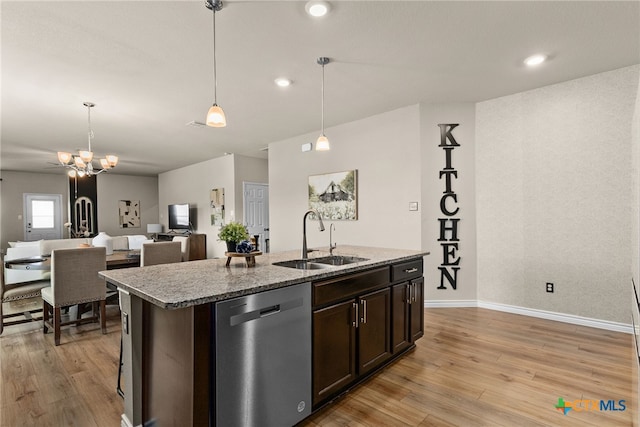 kitchen with light hardwood / wood-style floors, dishwasher, hanging light fixtures, sink, and an island with sink