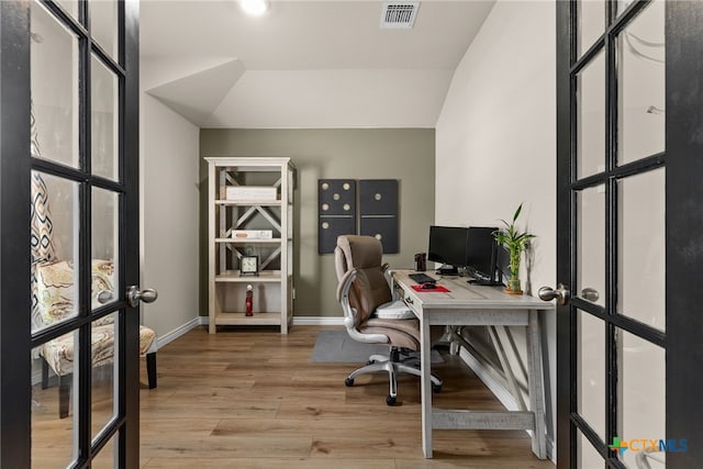 office space featuring french doors, hardwood / wood-style floors, and vaulted ceiling