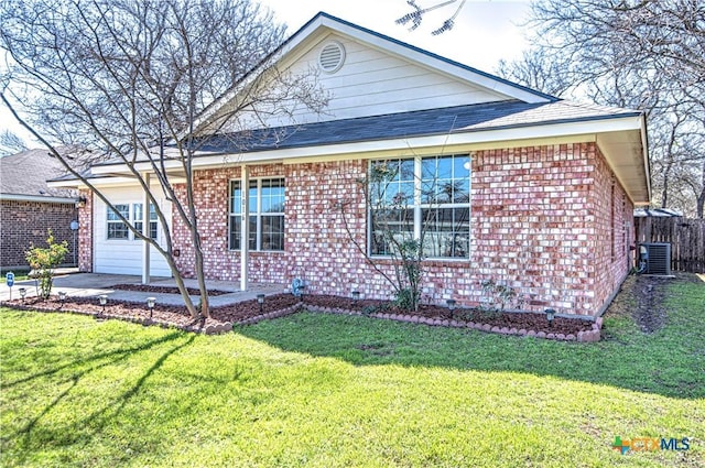 view of front facade with a garage, central AC, a front lawn, and brick siding