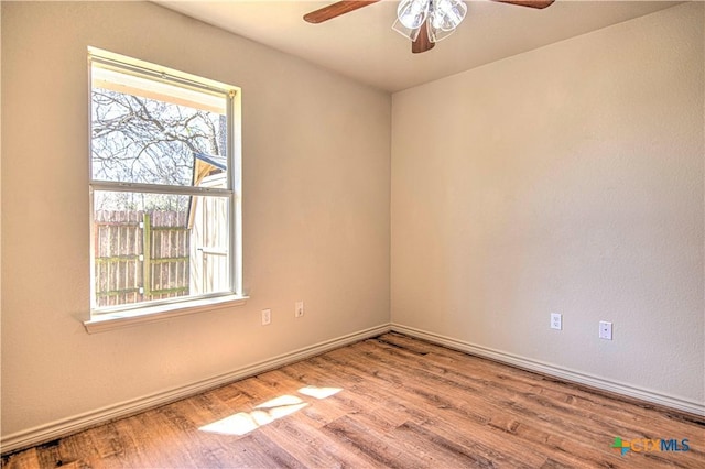 unfurnished room with a ceiling fan, baseboards, and wood finished floors