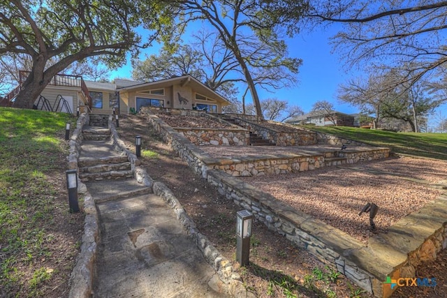 exterior space with stairs and a yard