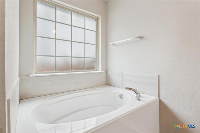 610 Hobby Rd, Copperas Cove, TX 76522 - bathroom with a textured wall, a garden tub, and a healthy amount of sunlight