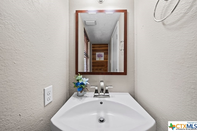 bathroom featuring a textured ceiling and sink