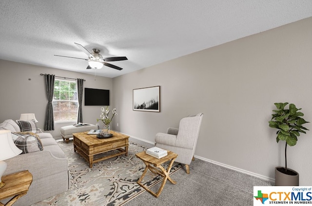 carpeted living room with a textured ceiling and ceiling fan