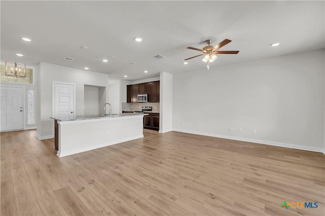 1531 Hillside Dr, Temple, TX 76502 - kitchen with stainless steel appliances, dark brown cabinets, a sink, light wood finished floors, and baseboards