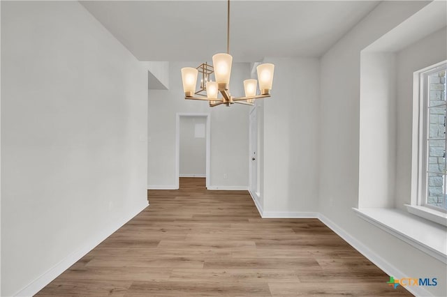 1531 Hillside Dr, Temple, TX 76502 - unfurnished dining area with a chandelier, light wood finished floors, and baseboards