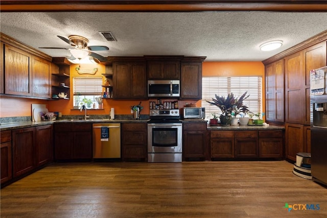 725 Baffin Dr, Port Mansfield, TX 78598 - kitchen featuring appliances with stainless steel finishes, open shelves, dark countertops, dark wood finished floors, and a textured ceiling