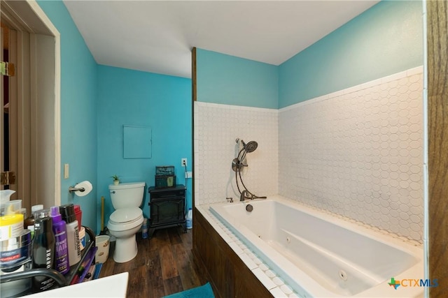 725 Baffin Dr, Port Mansfield, TX 78598 - bathroom with wood finished floors, a wood stove, toilet, and a jetted tub