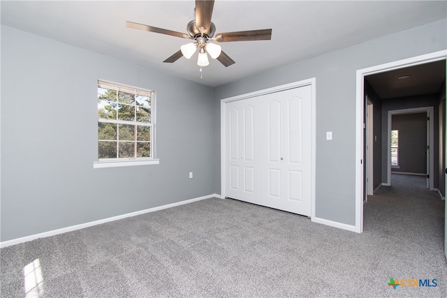 unfurnished bedroom with ceiling fan, carpet flooring, and a closet