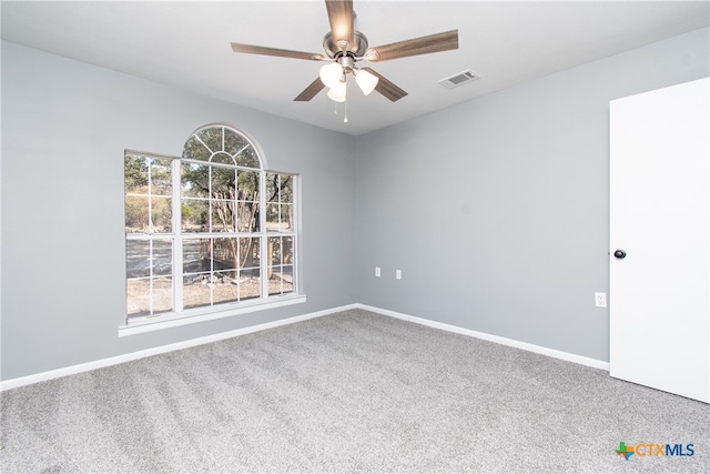 carpeted spare room featuring ceiling fan