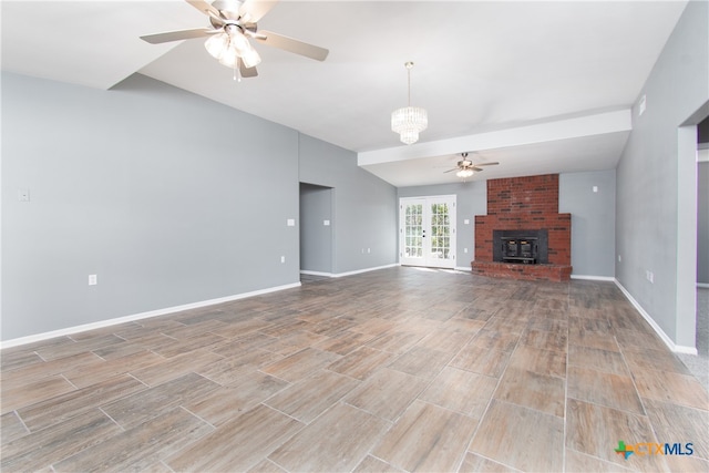 unfurnished living room featuring french doors and ceiling fan with notable chandelier