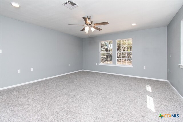 carpeted spare room featuring ceiling fan