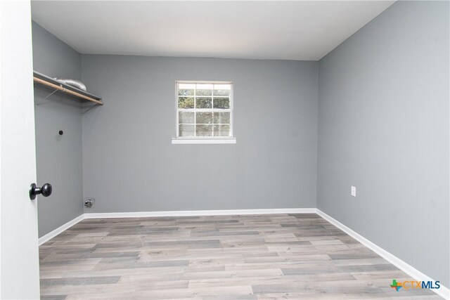 clothes washing area featuring light hardwood / wood-style floors and electric dryer hookup