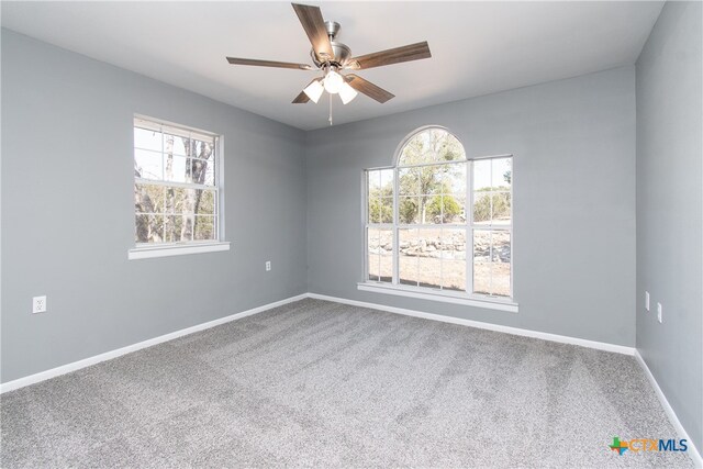 carpeted spare room with ceiling fan