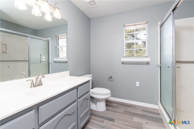 bathroom with a shower with door, wood-type flooring, toilet, and vanity