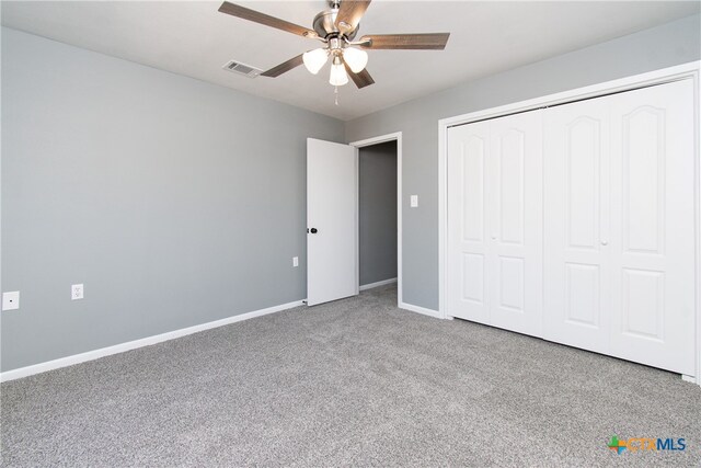 unfurnished bedroom with ceiling fan, a closet, and carpet floors