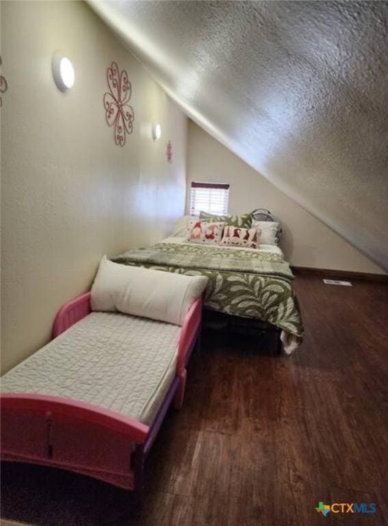 1123 N Beal St, Belton, TX 76513 - bedroom with vaulted ceiling, a textured ceiling, and wood finished floors