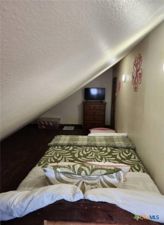 1123 N Beal St, Belton, TX 76513 - bedroom featuring lofted ceiling and a textured ceiling