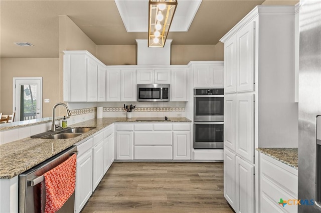 1205 Bowen Ave, Copperas Cove, TX 76522 - kitchen featuring stainless steel appliances, a sink, white cabinets, and light wood-type flooring