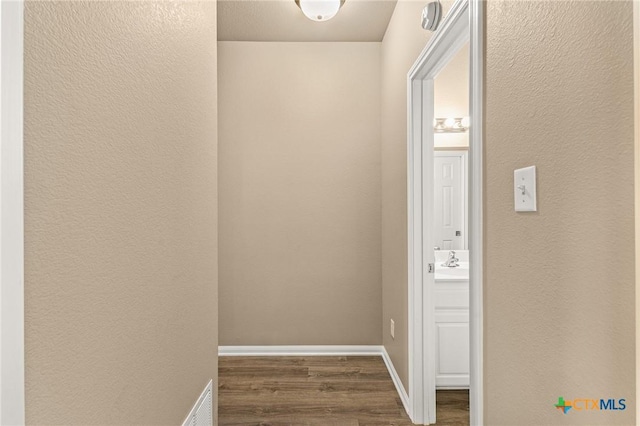 1205 Bowen Ave, Copperas Cove, TX 76522 - corridor with dark wood-style flooring, a textured wall, baseboards, and a sink