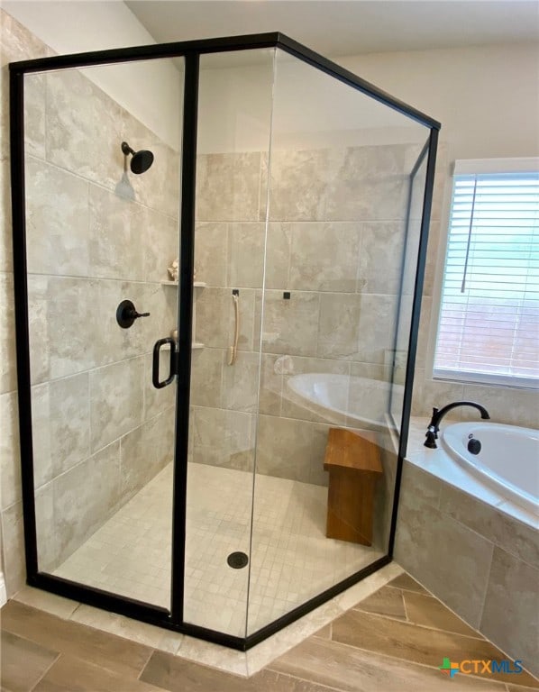 bathroom featuring a bath and a stall shower