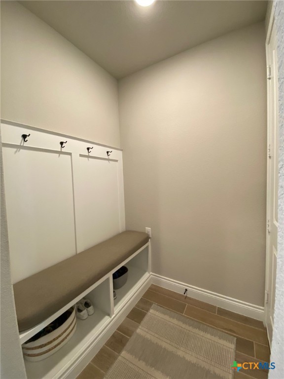 mudroom featuring baseboards and wood finish floors