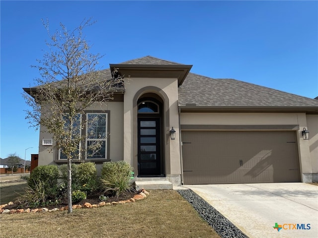 view of front of house with concrete driveway, an attached garage, roof with shingles, and stucco siding