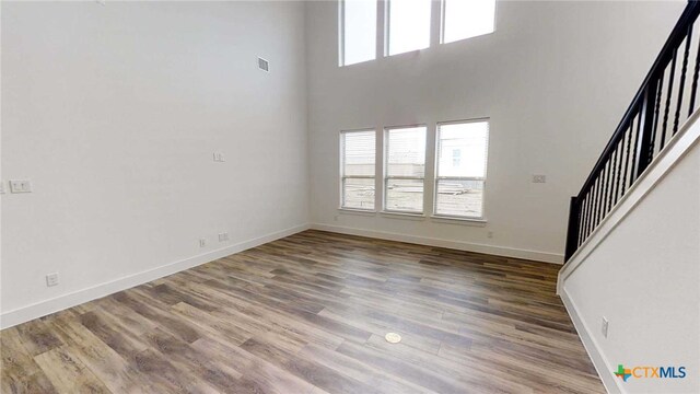 1822 Nettletree Rd, New Braunfels, TX 78132 - unfurnished living room featuring stairs, a wealth of natural light, and wood finished floors