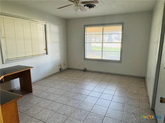 spare room with ceiling fan and light tile patterned flooring