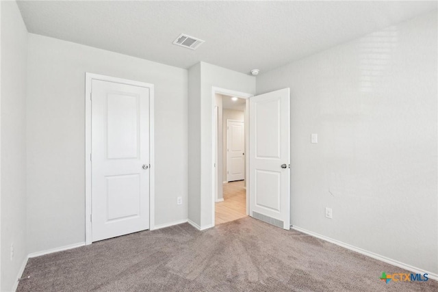 unfurnished bedroom with baseboards, visible vents, and carpet flooring