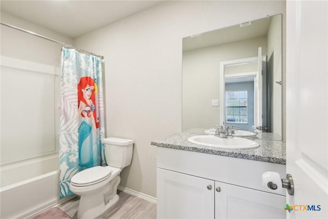 bathroom featuring shower / bath combo, baseboards, toilet, wood finished floors, and vanity