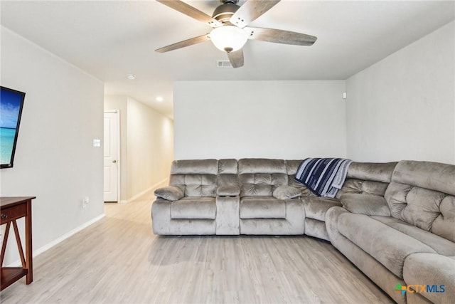 living room with a ceiling fan, visible vents, baseboards, and wood finished floors