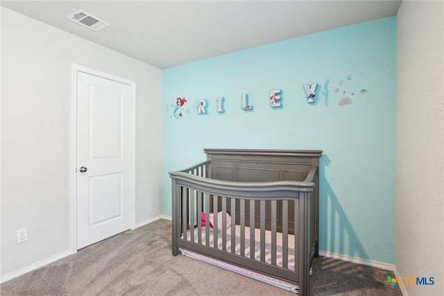 carpeted bedroom with visible vents, a crib, and baseboards