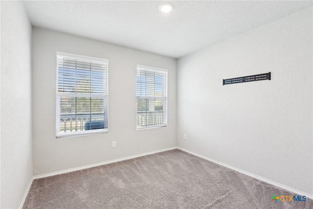 unfurnished room featuring carpet floors and baseboards