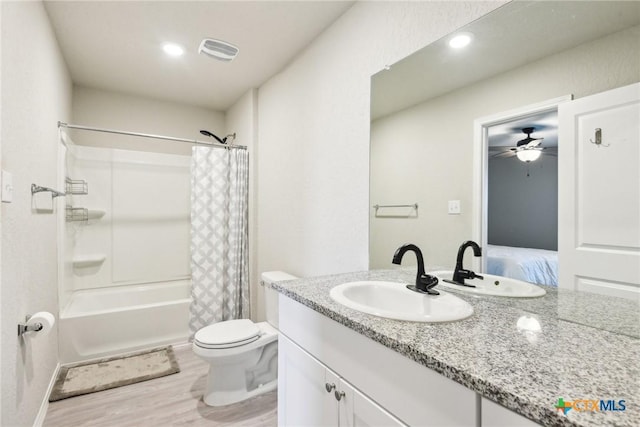 full bath featuring visible vents, toilet, shower / bath combo with shower curtain, vanity, and wood finished floors