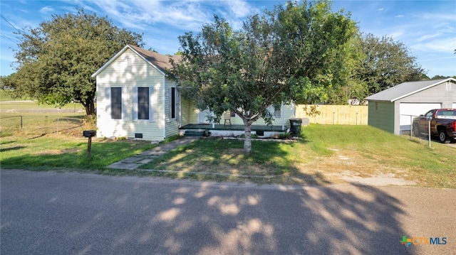 view of front of home with a garage, an outdoor structure, and a front yard