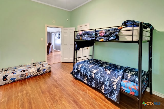 bedroom featuring hardwood / wood-style floors and crown molding