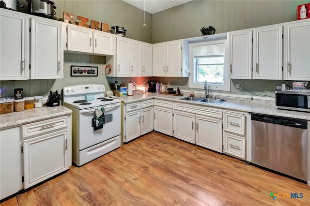 kitchen featuring white cabinets, stainless steel appliances, sink, and light hardwood / wood-style flooring