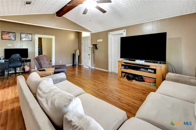 living room featuring hardwood / wood-style floors, ceiling fan, and lofted ceiling with beams