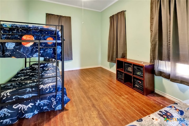 bedroom with hardwood / wood-style floors and crown molding