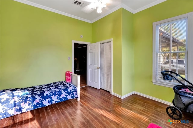 bedroom featuring ceiling fan, wood-type flooring, a closet, and crown molding