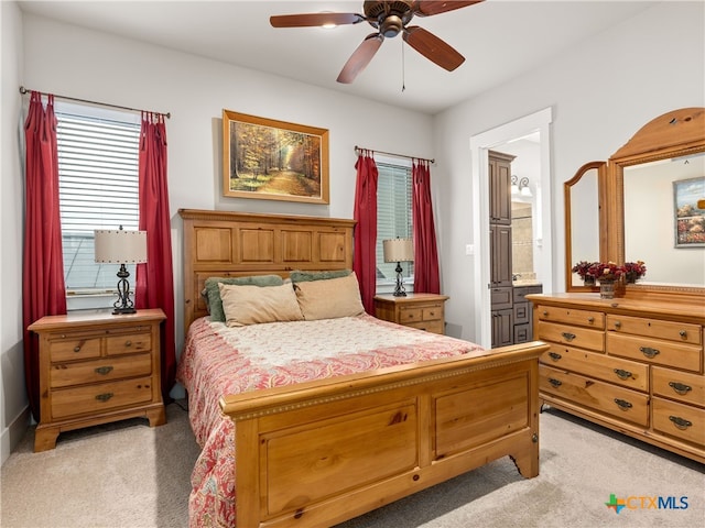 carpeted bedroom with ceiling fan and ensuite bath