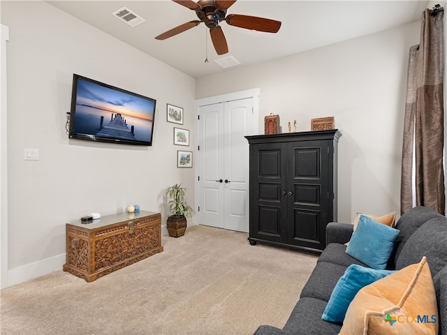 living area with ceiling fan and light carpet