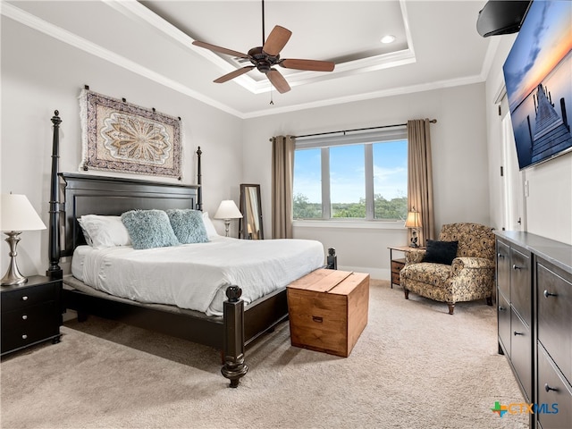 carpeted bedroom featuring a raised ceiling, ornamental molding, and ceiling fan