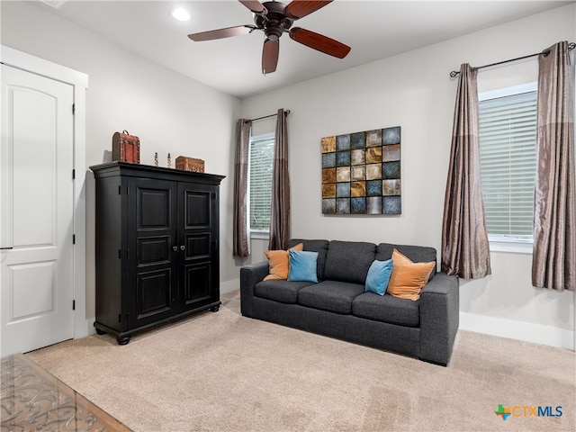 living room with ceiling fan and light colored carpet