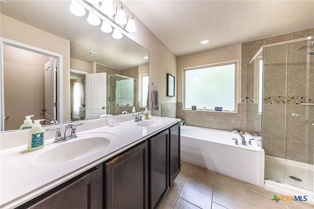 4431 Hogg, San Antonio, TX 78223 - full bath with a shower stall, double vanity, a garden tub, tile patterned floors, and tile walls