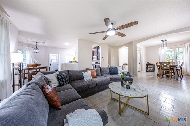 4431 Hogg, San Antonio, TX 78223 - living room featuring arched walkways, healthy amount of natural light, ceiling fan, and tile patterned flooring