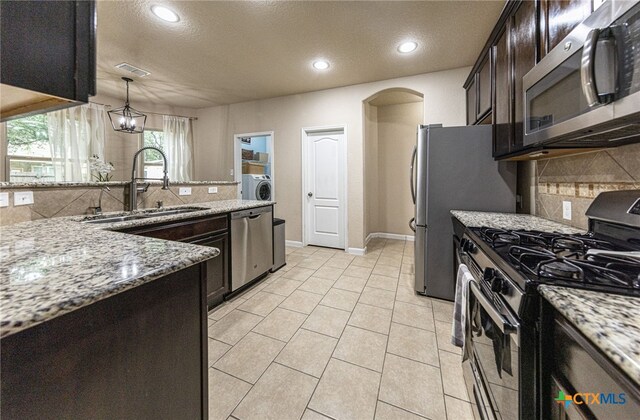 4431 Hogg, San Antonio, TX 78223 - kitchen featuring appliances with stainless steel finishes, backsplash, light stone counters, recessed lighting, and a textured ceiling